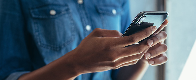 Closeup of someone's hands using a cell phone.