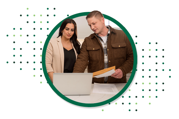 Couple Looking at Computer Holding Paper Bills