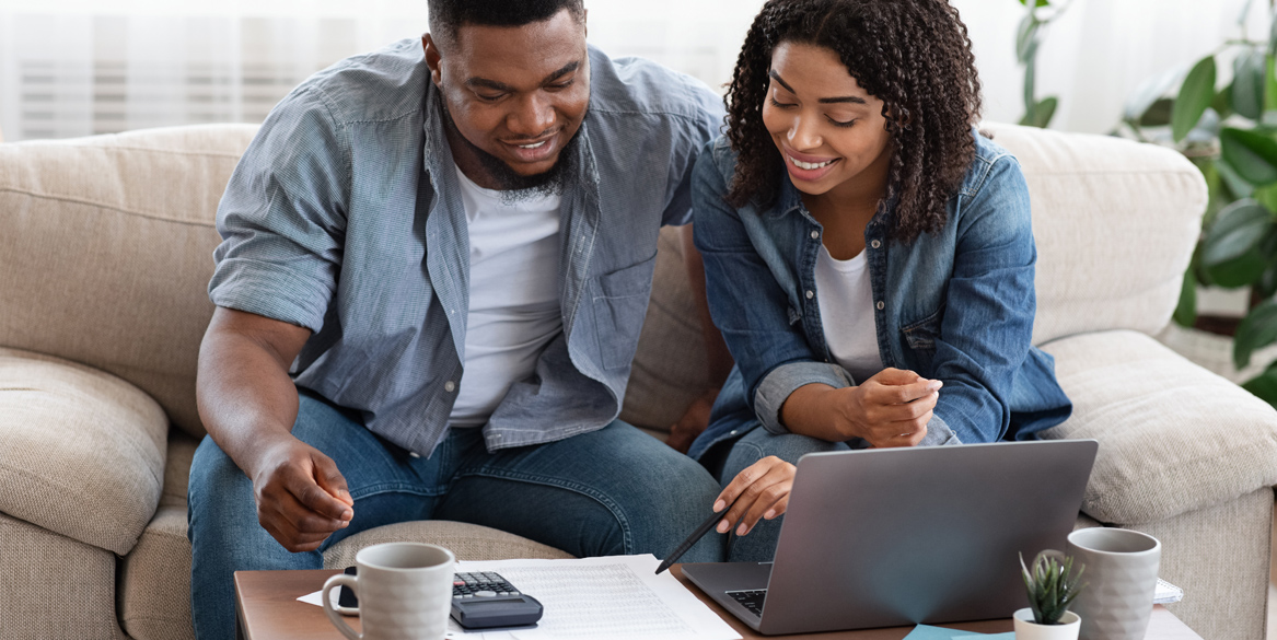 Couple discussing budget over paperwork and computers