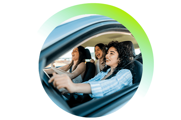 Three friends driving in a car and laughing.
