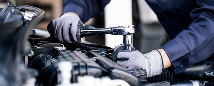 mechanical breakdown protection - mechanic's hands working on a car engine